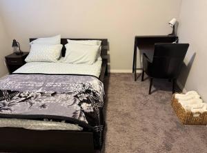 a bedroom with a bed and a desk and a chair at Quiet Comfortable 1-Bedroom in Calgary