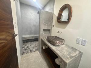 a bathroom with a stone sink and a mirror at Hotel Almendros Bonfil in Acapulco +27 photos
