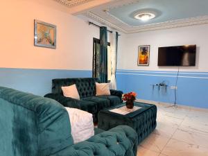 a living room with two couches and a tv at Résidence Yavanie in Kribi
