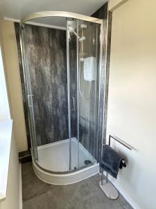 a shower with a glass enclosure in a bathroom at The old greengrocers Battlesbridge in Rawreth
