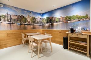 a dining room with a river mural on the wall at Marnix360apartments-Suites Jordaan in Amsterdam