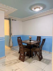 a dining room with a wooden table and chairs at Résidence Yavanie in Kribi