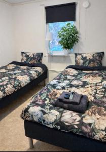 a bedroom with two beds and a window at Frost Longstay City in Kiruna