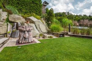 a garden with a statue in the grass at Pagórek w Brennej in Brenna