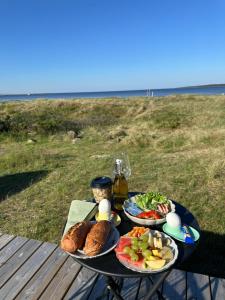 a table with two plates of food on a table near the beach at Kottehusen på Söder in Halmstad
