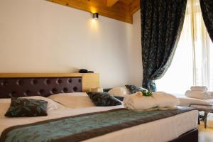 a bedroom with three beds with curtains and a window at Hotel Natura in Castel di Sangro +39 photos