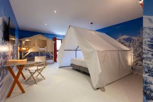 a bedroom with a bed and a tent at Hotel Base Camp Lodge - Bourg Saint Maurice in Bourg-Saint-Maurice