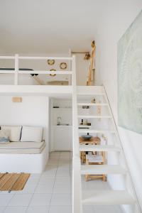 a white room with a bunk bed and stairs at Nissos Suites in Apollonia