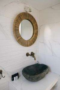 a bathroom with a sink and a mirror on the wall at Nissos Suites in Apollonia