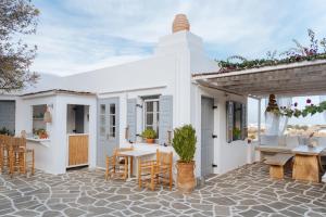 a white house with a table and chairs at Nissos Suites in Apollonia