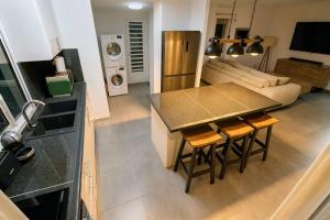 a kitchen and living room with a table and chairs at Villa 4 étoiles Le Pic de Malendure in Bouillante