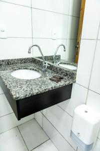 a bathroom with two sinks and a toilet at Hotel Rota 090 in Piraí do Sul +84 photos