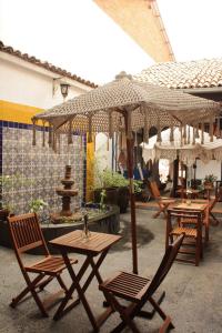 a group of tables and chairs with umbrellas at PASEO REAL HOTEL BOUTIQUE in Uruapan del Progreso