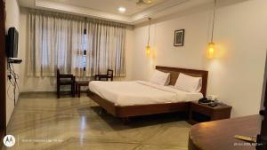 a hotel room with a bed and a table at Hotel Raya's Annexe 1 in Kumbakonam