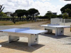 two ping pong tables sitting in a park at Mobilhome Océalia T3 in Plouescat