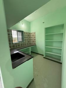 an empty kitchen with a sink and shelves at JMS Garden Villa in Kanchipuram
