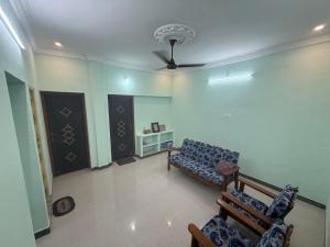 a living room with a couch and a ceiling fan at JMS Garden Villa in Kanchipuram