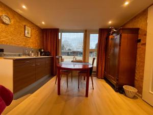 a kitchen with a wooden table and a wooden floor at Equi Guidance Studio in Wapenveld