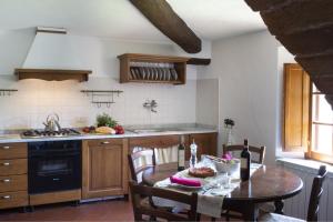 a kitchen with a table and a stove and a sink at Montestigliano in Sovicille