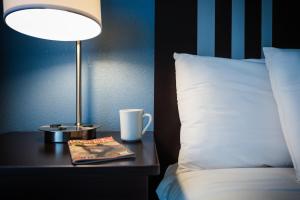 a table with a lamp and a book next to a bed at Glenstone Lodge in Gatlinburg