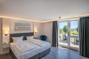 a hotel room with a bed and a large window at Hotel Königslinie in Sassnitz +54 photos