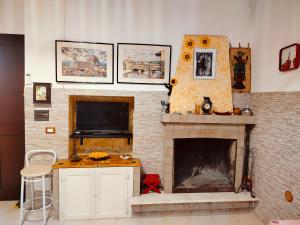 a living room with a fireplace with a tv at CASA NATURA - CAMPAGNA e MARE - in Marconia