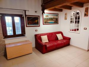 a living room with a red couch and a window at CASA NATURA - CAMPAGNA e MARE - in Marconia +12 photos