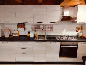 a kitchen with white cabinets and a sink at CASA NATURA - CAMPAGNA e MARE - in Marconia