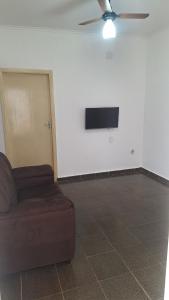 a living room with a couch and a tv on a wall at Casa para 6 pessoas completa in Ribeirão Preto