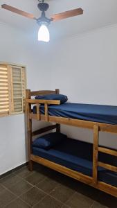 two bunk beds in a room with a ceiling fan at Casa para 6 pessoas completa in Ribeirão Preto