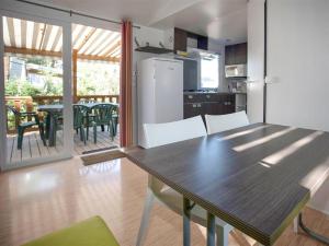 a kitchen and dining room with a table and a table and chairs at Camping La Siesta - Maeva in L'Aiguillon-la-Presqu'île