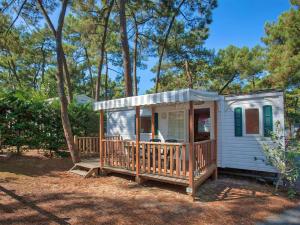 a small white house with a porch and trees at Camping La Siesta - Maeva in L'Aiguillon-la-Presqu'île