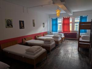 a row of beds in a room with red curtains at Black Forest Hostel in Freiburg im Breisgau