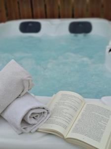 an open book sitting on a table next to a bath tub at Gîte " Ô PARADIS" in Douelle +30 photos