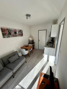 a living room with a couch and a table at Logis Hotel-restaurant Les Glycines in Arles-sur-Tech