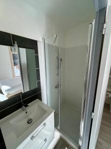 a bathroom with a glass shower and a sink at Logis Hotel-restaurant Les Glycines in Arles-sur-Tech +30 photos