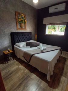 a bedroom with a large bed and a window at Pousada Flor De Lótus Cipó in Serra do Cipo