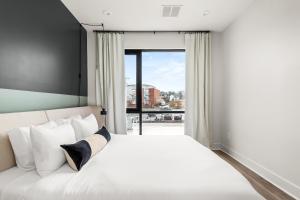 a bedroom with a white bed and a large window at The Eighteen by Kasa in Nashville