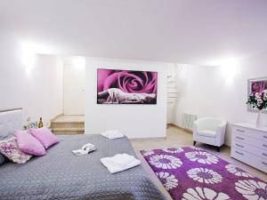 a bedroom with a large bed with pink pillows at Apartment Bella Vista In Mezzegra with POOL sleeps 6- by Italian Apartments in Mezzegra