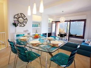 a dining room with a glass table and blue chairs at Apartment Bella Vista In Mezzegra in Mezzegra
