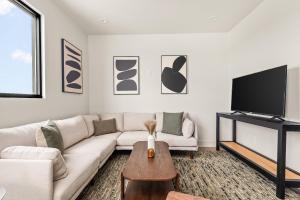 a living room with a white couch and a tv at The Eighteen by Kasa in Nashville +83 photos