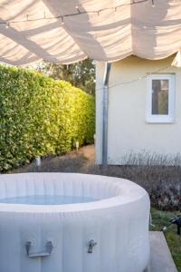 a large white tub sitting under a canopy at Volt Egyszer Egy Apartman Pécs in Pécs