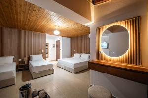 a hotel room with two beds and a mirror at ABEDINI Boutique Hotel Ksamil in Ksamil