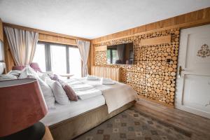a bedroom with a bed and a wall of logs at Dom Beskidy in Brenna