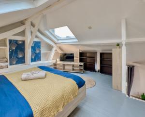 a bedroom with a large bed and a skylight at Le Duplex Cosy in Clermont
