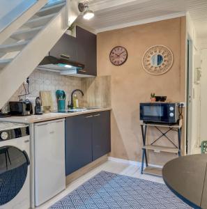a small kitchen with a sink and a microwave at Le Duplex Cosy in Clermont