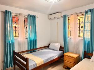 a bedroom with two beds and two windows at 1Dom Rep - Huge cozy 3 bedrooms - close to all transportation Jacobo Majluta - Residencial Paradise V Colina Arroyo 1 in Santo Domingo