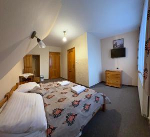a hotel room with two beds and a tv at Dom Wypoczynkowy Maniek in Białka Tatrzańska