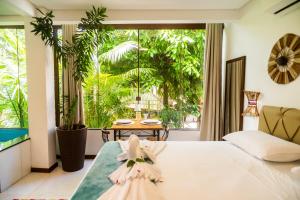 a bedroom with a bed and a large window at Villa Botanic Garden in Itacaré +124 photos