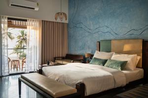 a bedroom with a large bed and a balcony at illa - By the sea in Udupi +24 photos